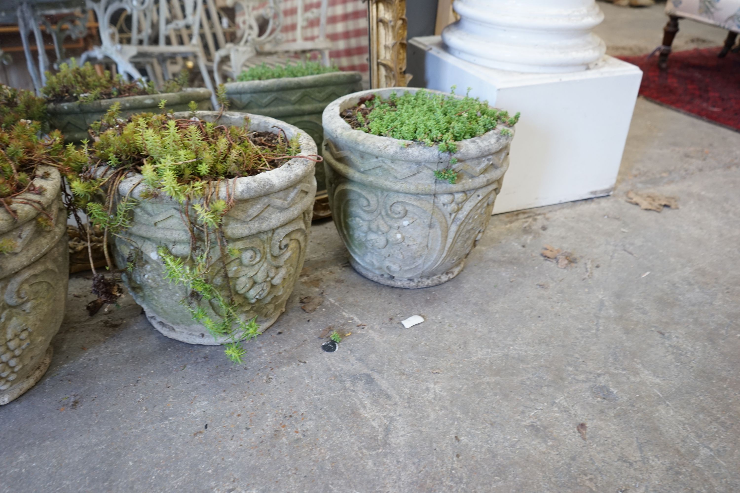 A set of four circular reconstituted stone garden planters, diameter 32cm, height 28cm